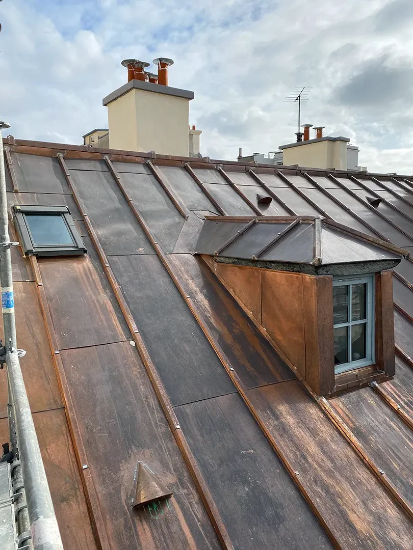 Toiture en zinc avec solins, faîtage et descentes pluviales sur bâtiment parisien