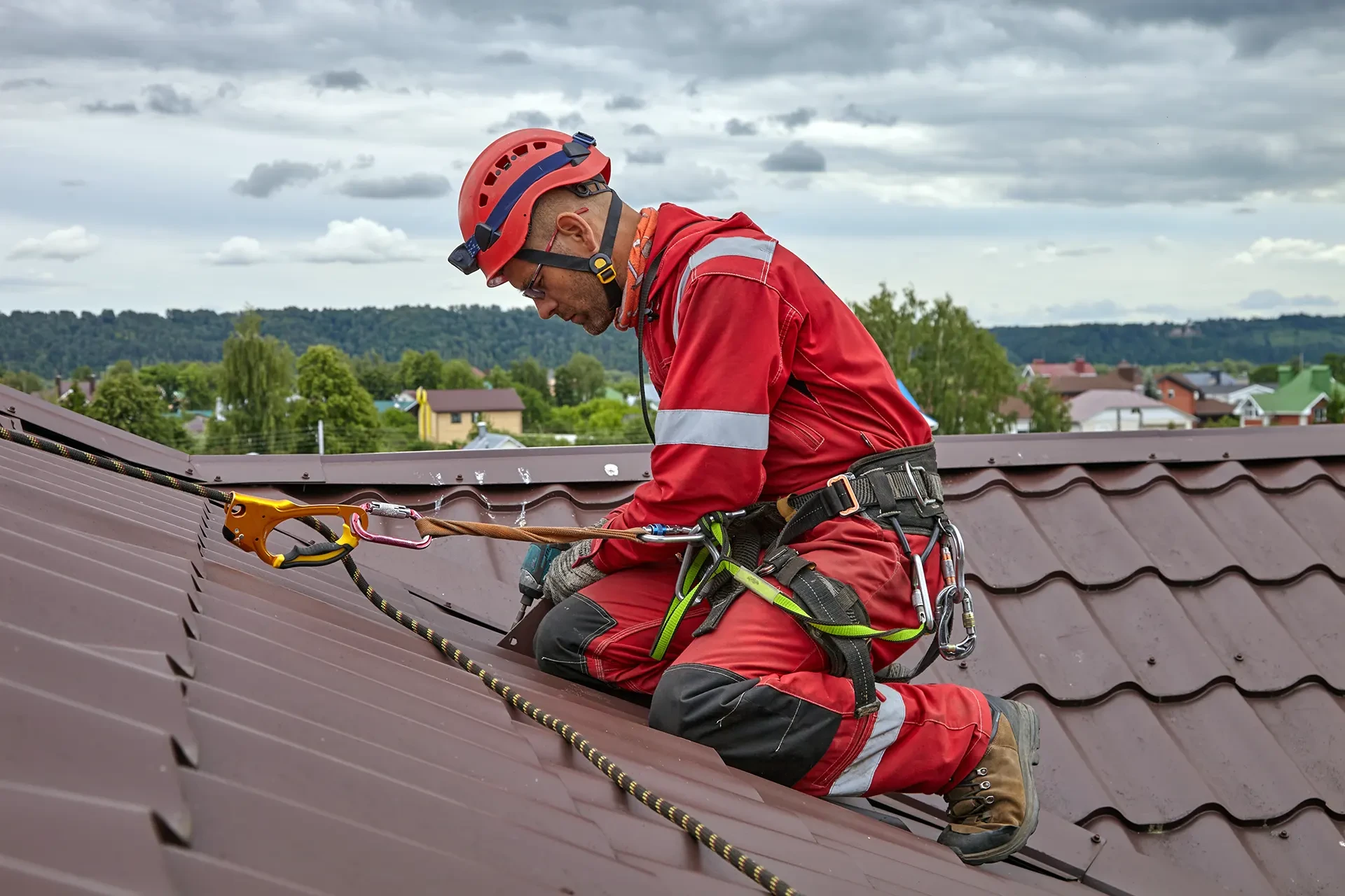 Homme et femme en casques de sécurité rouges examinent des plans architecturaux dans un bâtiment en construction